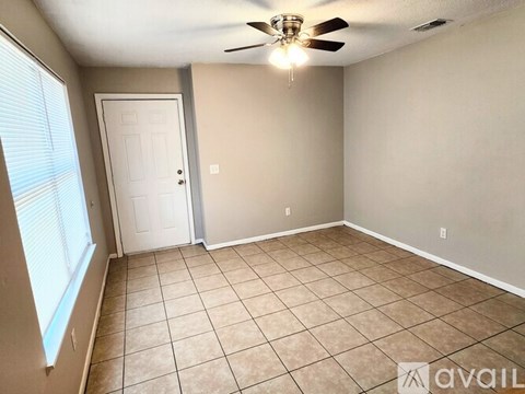 A room with a ceiling fan and tile flooring.