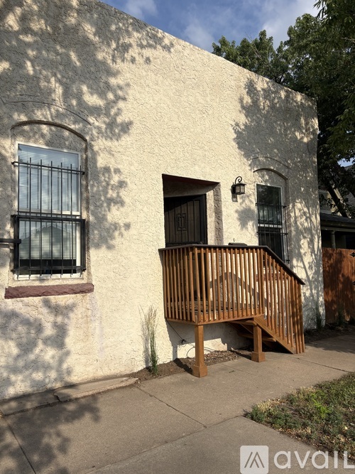 A white building with a brown wooden railing.
