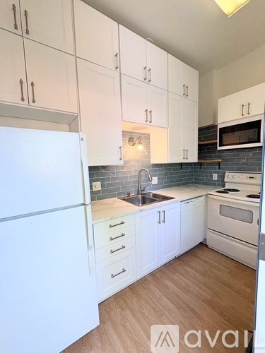 A kitchen with white cabinets and a white refrigerator.