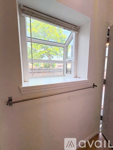A window with a view of trees and a fence outside.