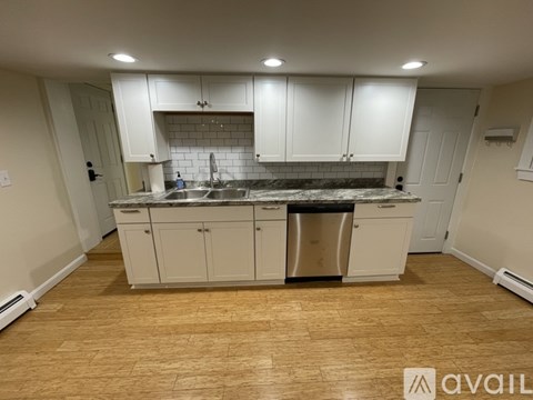 A kitchen with white cabinets and a black countertop.