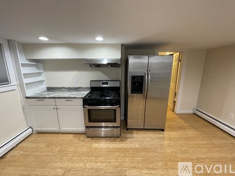 A kitchen with a refrigerator, oven, and stove top.