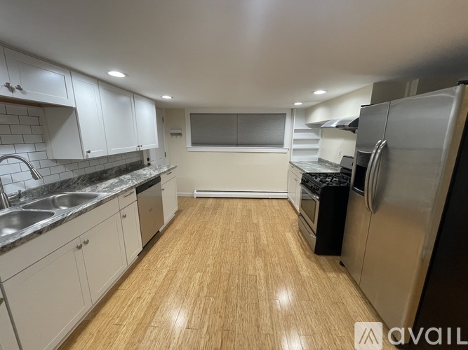 A kitchen with wooden floors and stainless steel appliances.