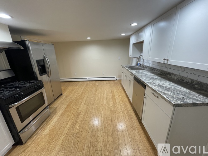 A kitchen with a stove top oven and a refrigerator.