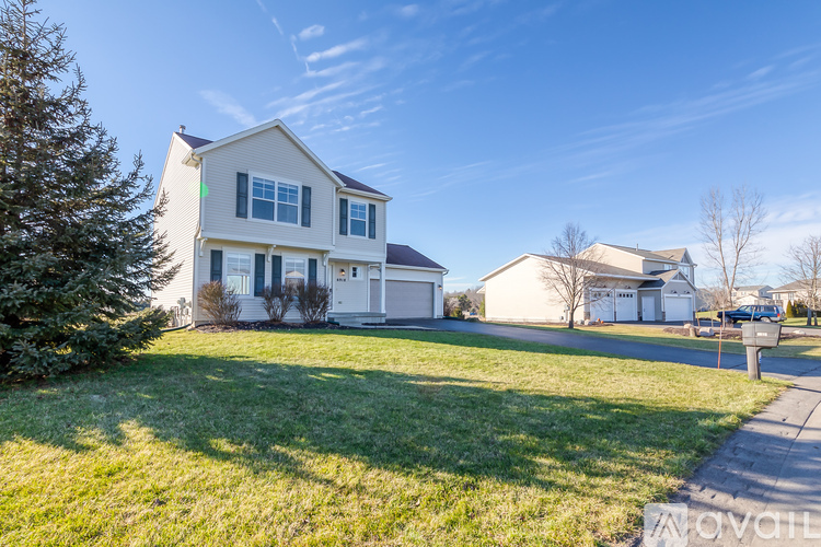 A house with a white exterior and a green lawn in front.