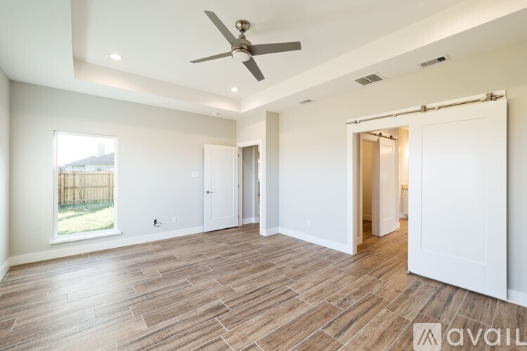 A spacious room with a ceiling fan and lighting fixtures.