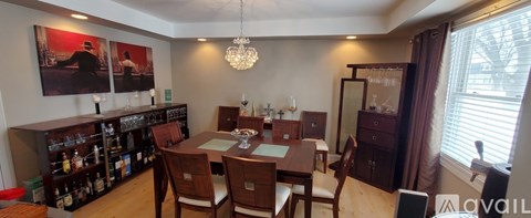 A dining room with a wooden table and chairs.