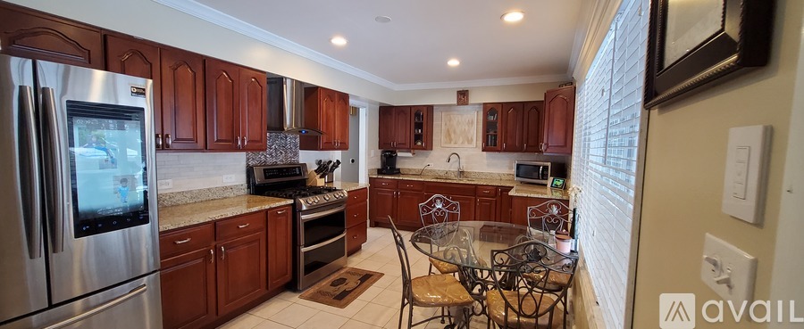 A kitchen with wooden cabinets and a glass table.