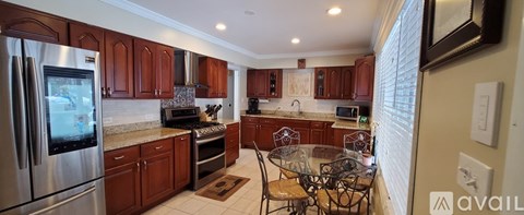 A kitchen with wooden cabinets and a glass table.