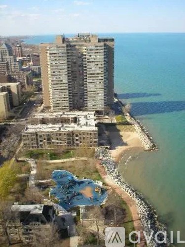 A tall building is situated next to a body of water.