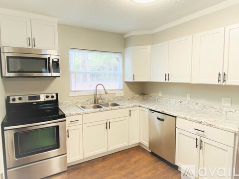 A kitchen with white cabinets and a stainless steel oven.