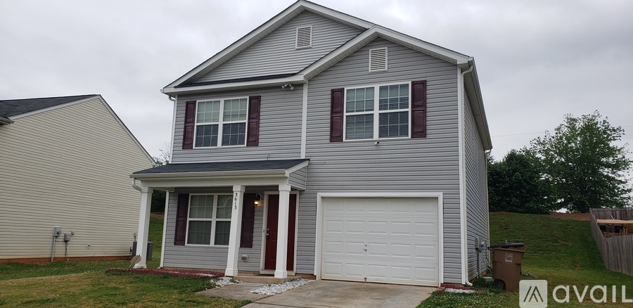 A two-story house with a garage is available for sale.