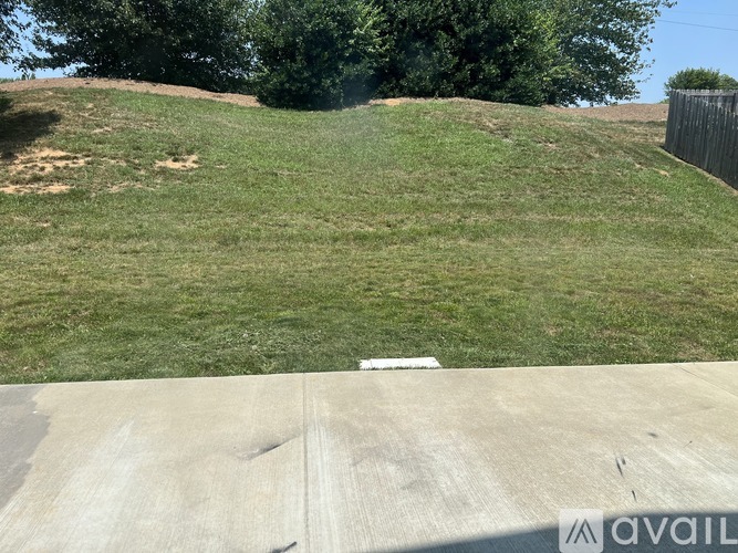 A grassy hill with a concrete slab in the foreground.
