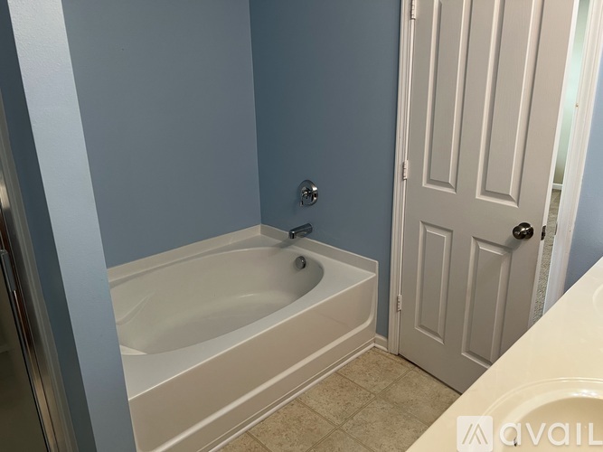 A white bathtub in a bathroom with blue walls.