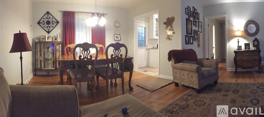 A living room with a couch, chairs, and a rug.