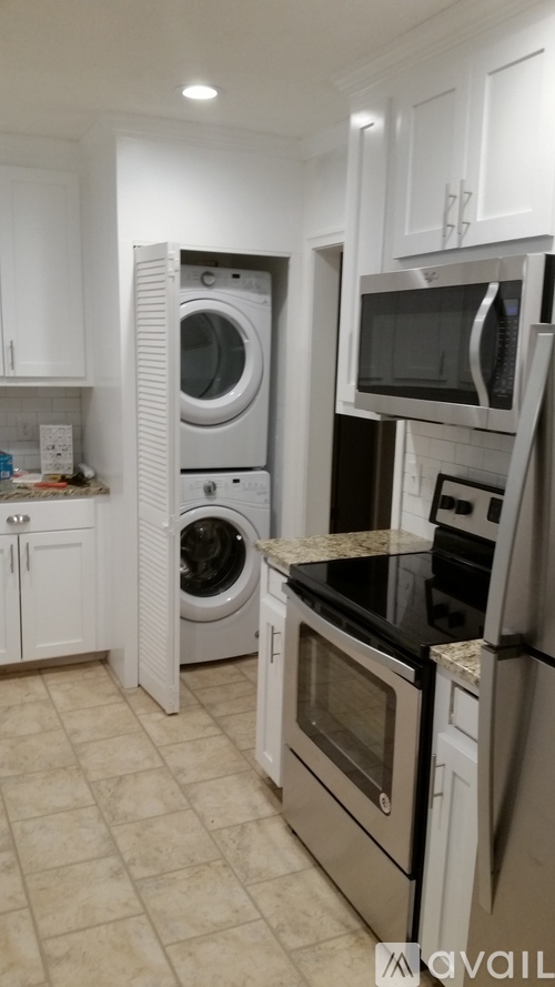 A kitchen with a white cabinet and a black counter top.