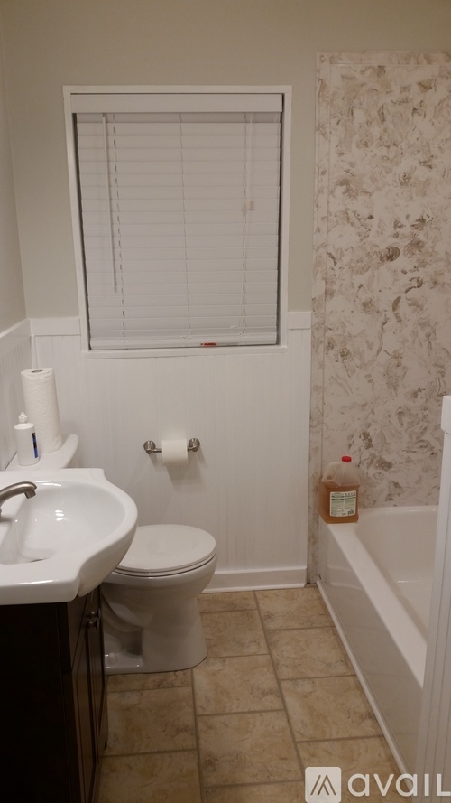 A bathroom with a toilet, sink, and bathtub.