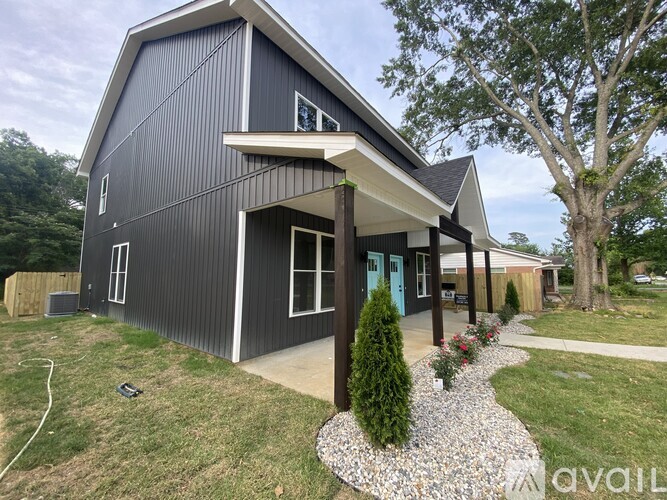 A modern house with a grey exterior and a blue door.
