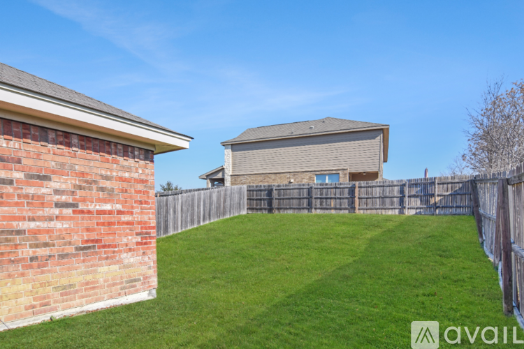 A backyard with a wooden fence and a grassy area.