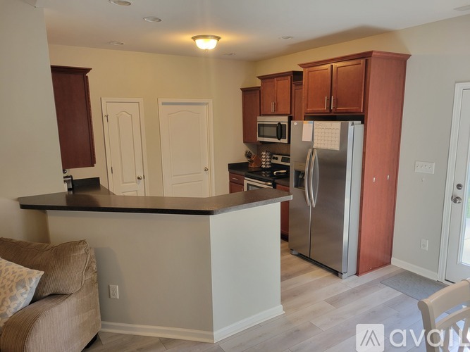 A kitchen with a refrigerator, microwave, and oven.