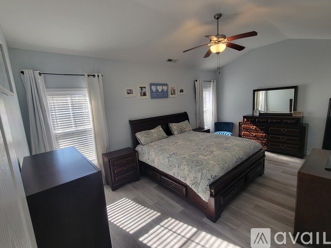 A bedroom with a bed, dresser, and mirror.