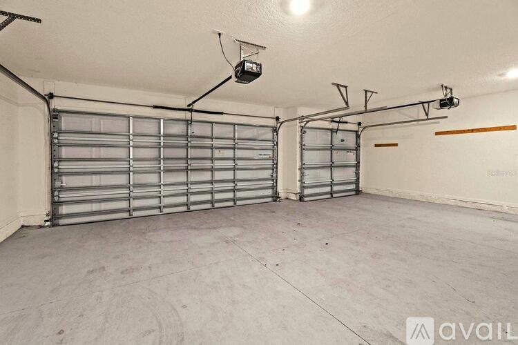 A spacious garage with two overhead lights and a closed shutter door.