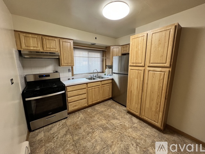 A kitchen with wooden cabinets and a black stove top oven.