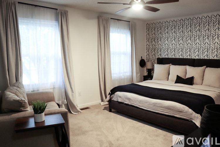 A well-lit bedroom with a large bed and a ceiling fan.