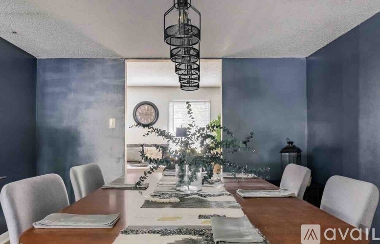 A dining room with a long table set for a meal.