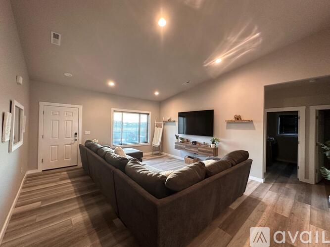A living room with a brown couch and a flat screen TV.