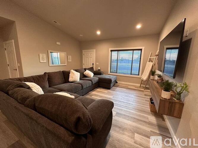 A living room with a brown couch and a wooden floor.