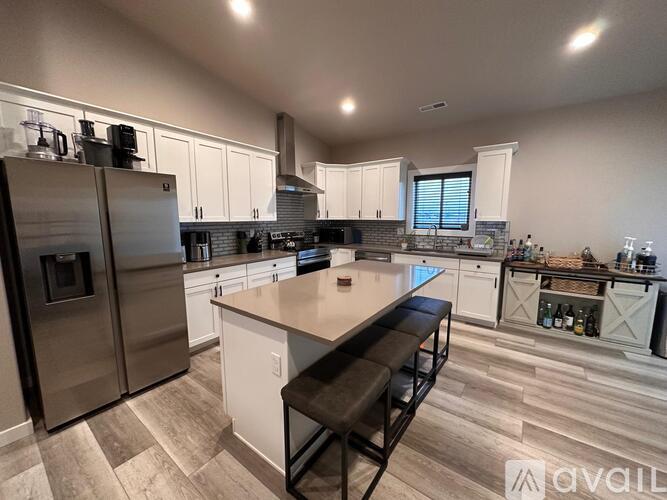 A kitchen with a refrigerator, stove, and island.