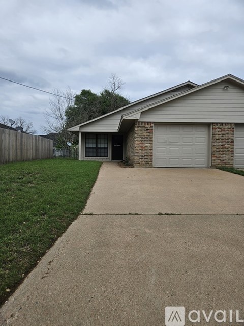A house with a garage and a driveway in front.