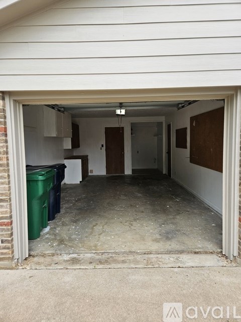 A garage with a white wall and a brown board on the wall.