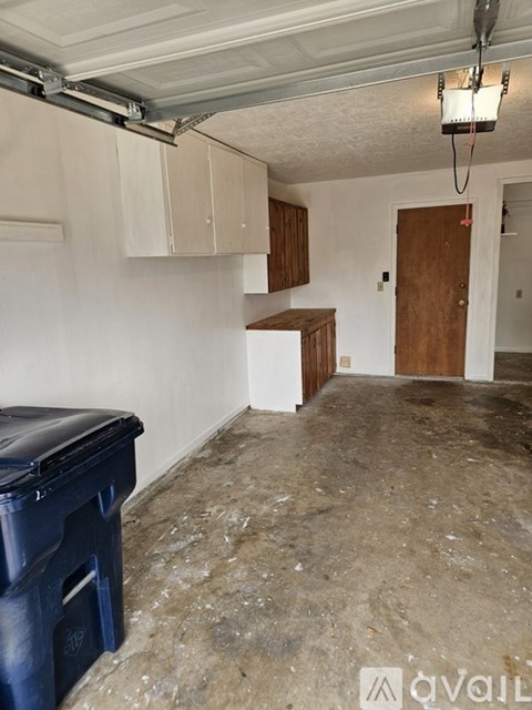 A room with a white wall and a wooden door.