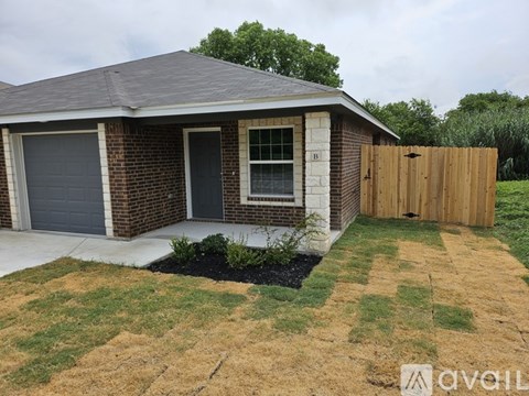 A house with a grey garage door and a brown wooden fence.