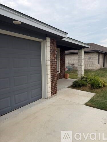 A brick house with a grey door and a window.