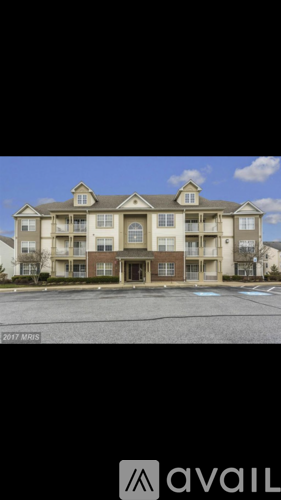 A large apartment building with a parking lot in front.