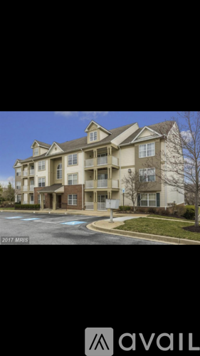 A large apartment building with a parking lot in front.