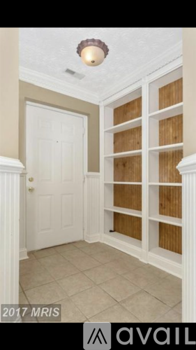 A white door is in a room with a wood paneled wall.