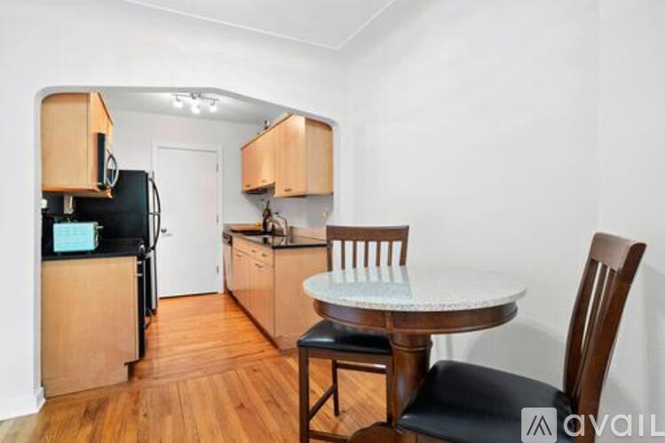 A kitchen with a table and chairs.