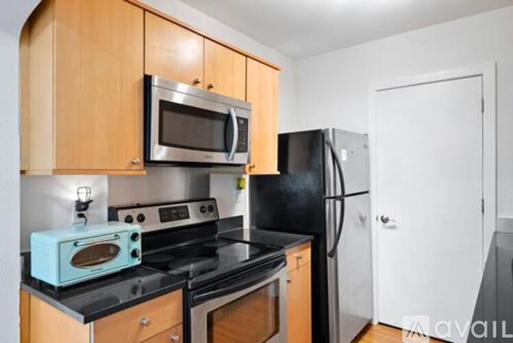 A kitchen with a black stove top oven and a black refrigerator.