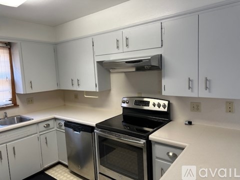 A kitchen with white cabinets and a black stove top oven.