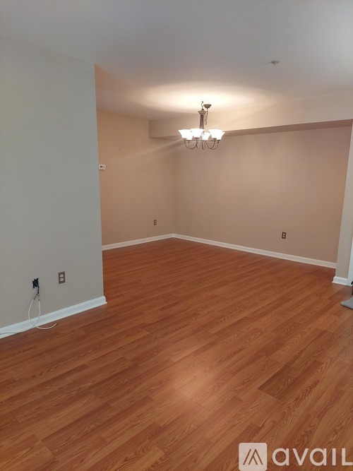 A room with wooden flooring and a chandelier.