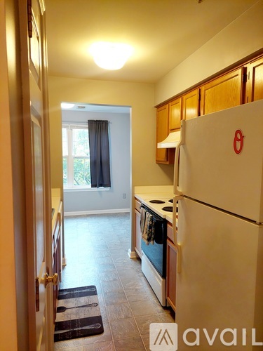 A kitchen with a white fridge and wooden cabinets.