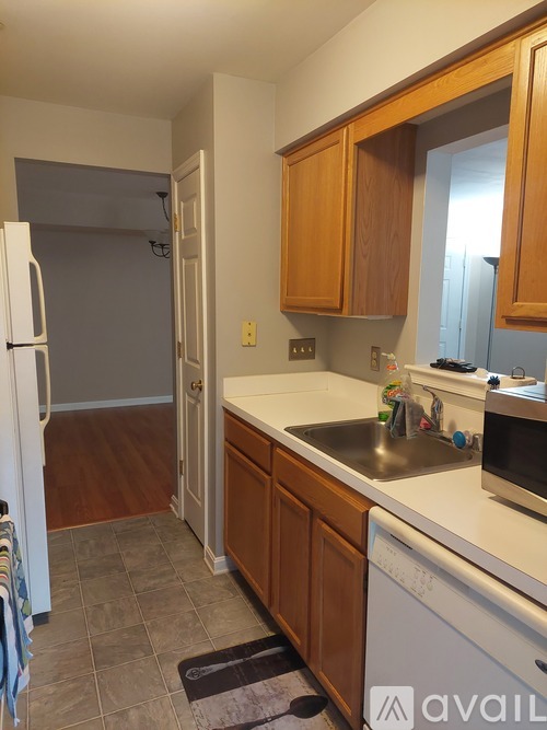 A kitchen with wooden cabinets and a white fridge.