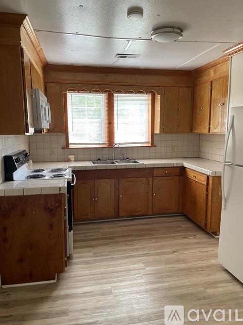 A kitchen with wooden cabinets and a white fridge.