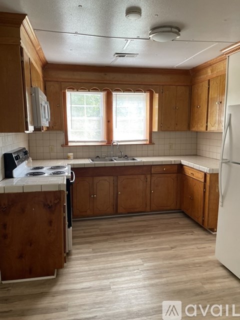 A kitchen with wooden cabinets and a white fridge.