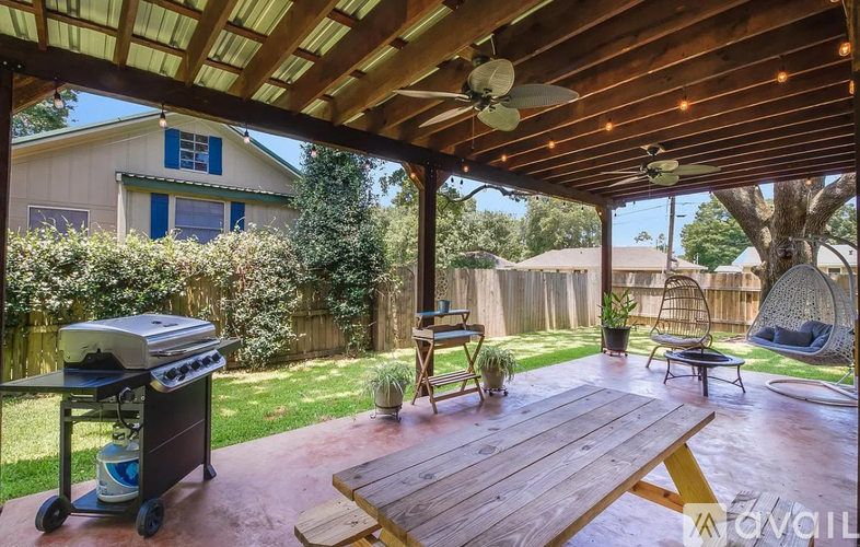 A wooden table is in the middle of a patio.
