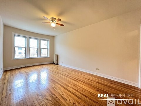 A room with wooden flooring and a ceiling fan.